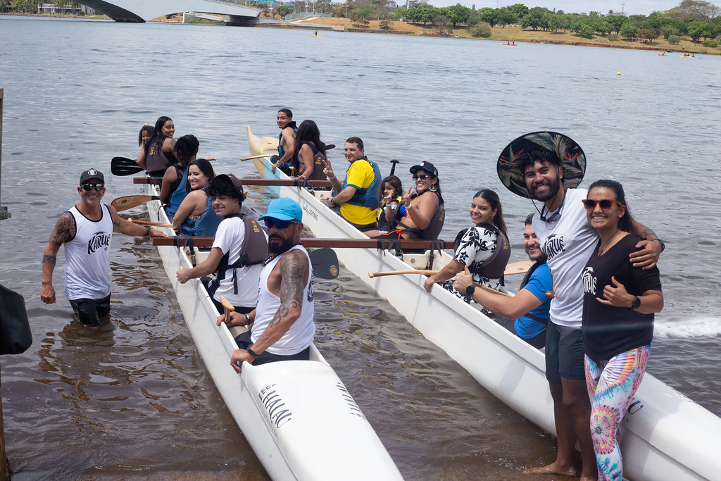 Participantes reunidos com canoas às margens do lago